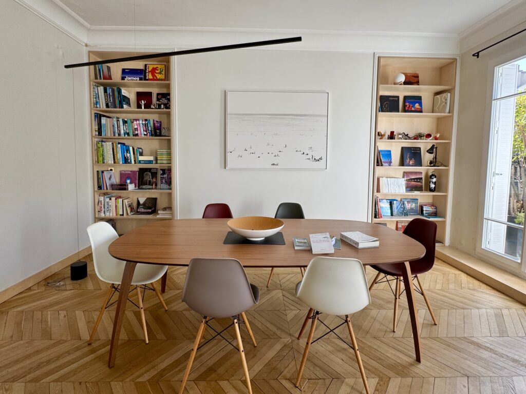 Deux bibliothèques sur mesure en contreplaqué bouleau intégrées de part et d’autre de la salle à manger d’un appartement parisien.